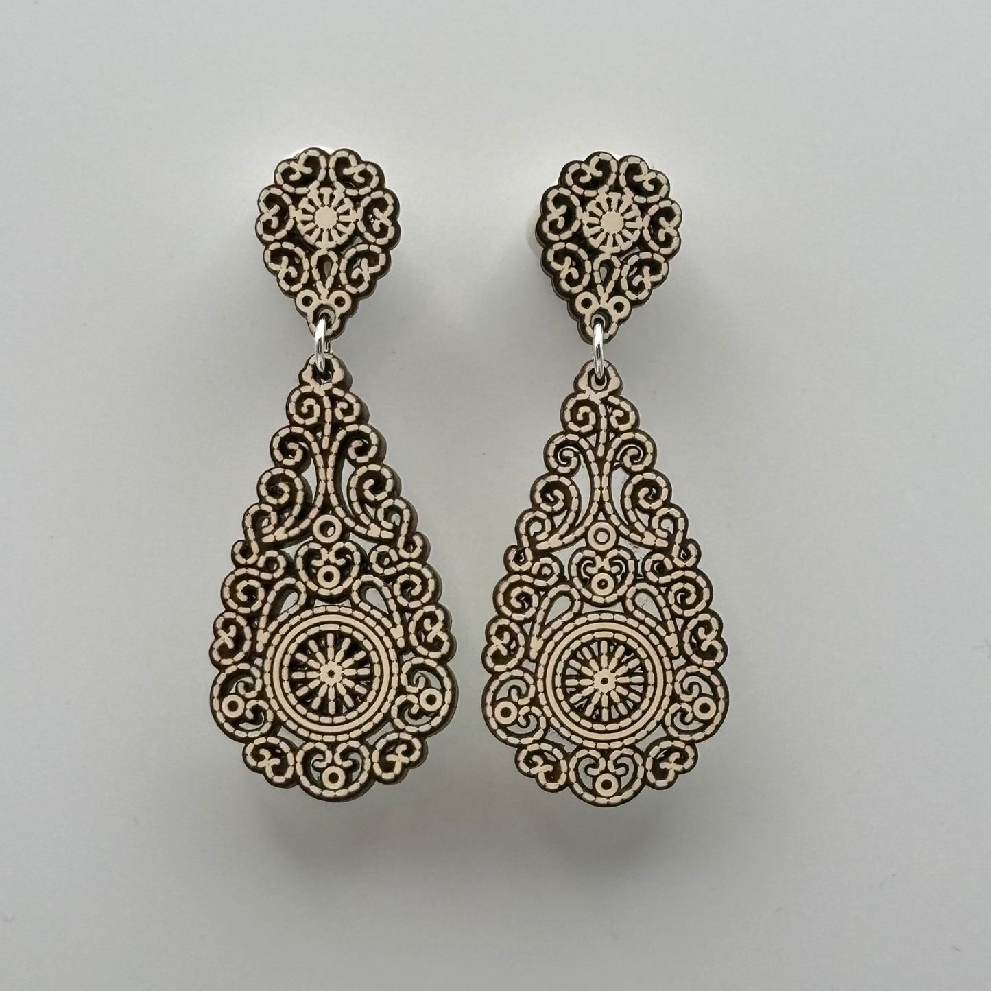 Ultraleichte Ohrringe aus Holz mit filigran gearbeitetem Motiv in Tropfenform in weiß